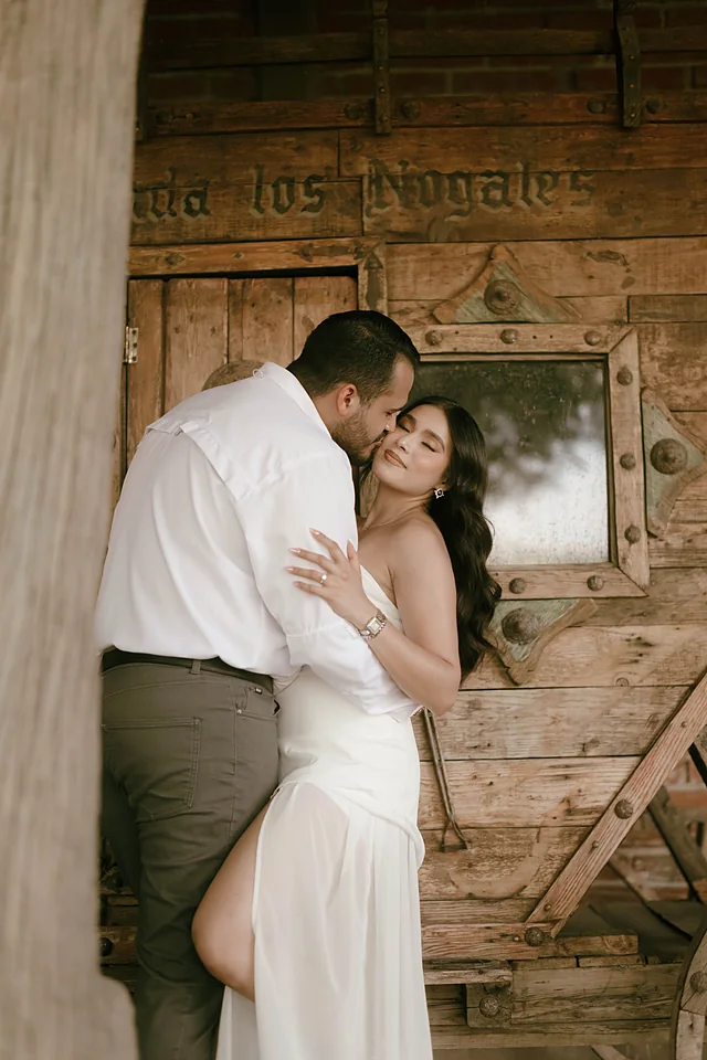 Yaritzy y Christian besándose junto al portón de la hacienda